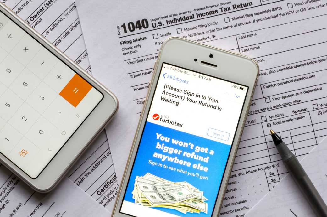 Tax forms with a phone viewing an email from TurboTax